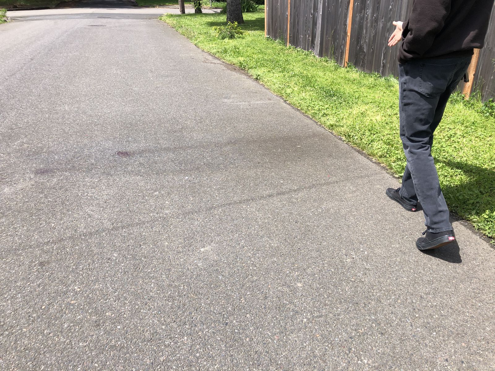 A neighbor shows the spot on Northeast Mason Street where residents found shattered glass from a silver Lexus stopped by police, and a blood spot on the pavement near where a motorist had been shot by police in an exchange of gunfire Friday night, May 6, 2022. 