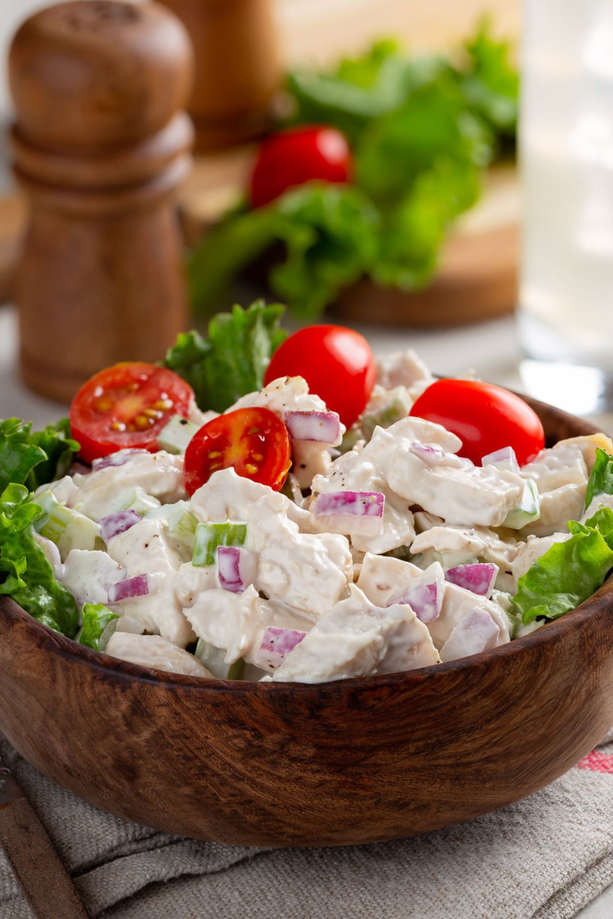 chicken salad in a wood bowl with tomatoes
