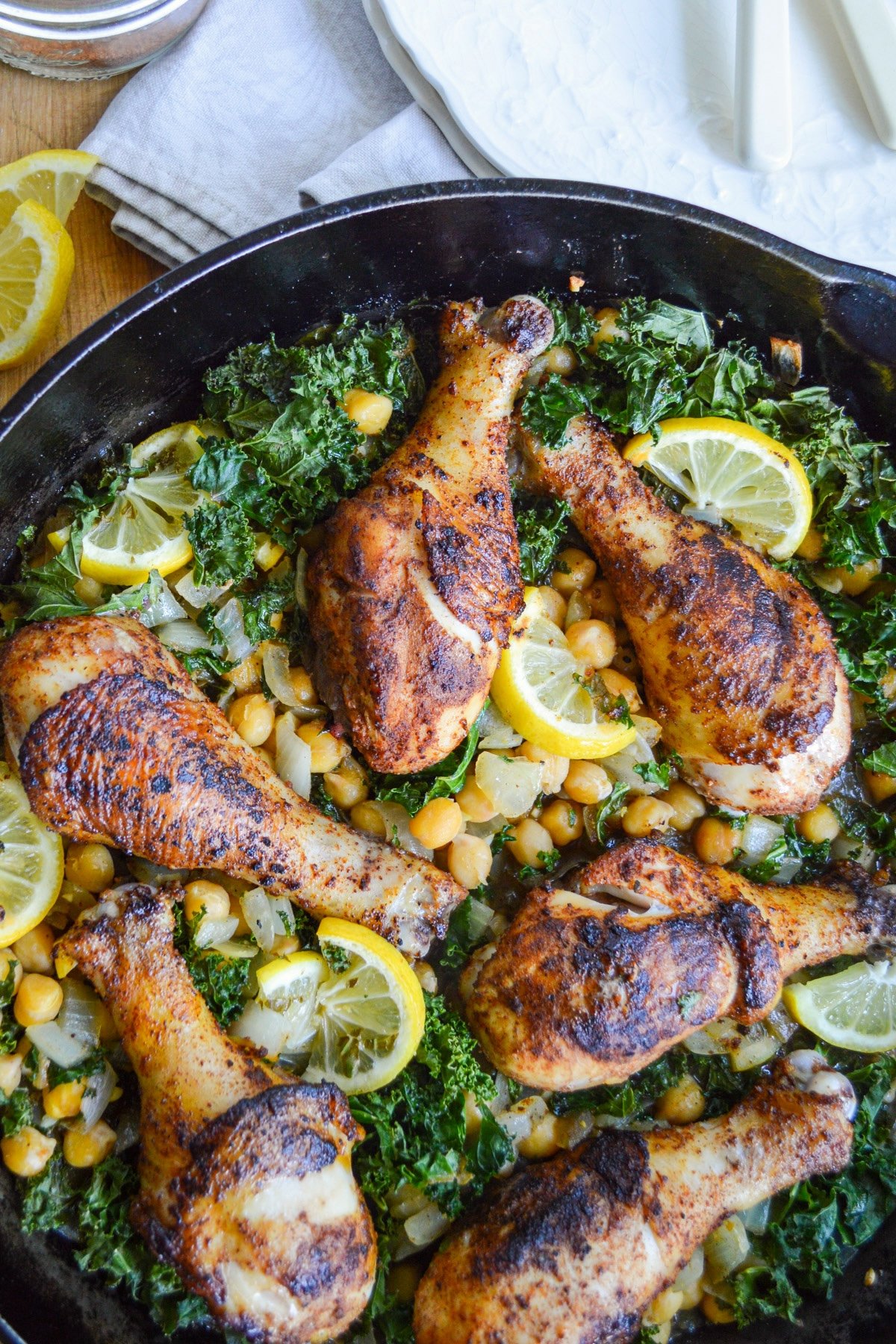 lemon chicken legs, beans and kale in cast iron skillet